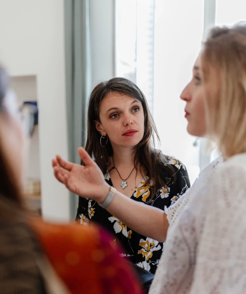Collaboratrices d’une entreprise en pleine discussion lors d’une réunion, reflétant l’esprit d’équipe, la collaboration et la dynamique professionnelle.